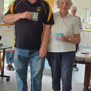 Man and woman holding cards, posing indoors