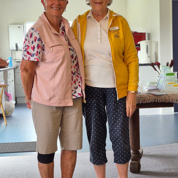 Two smiling women standing together indoors
