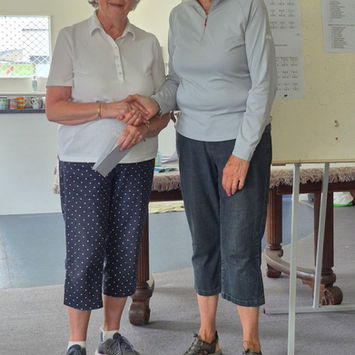 Two women shaking hands and smiling