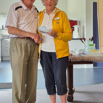 Man shaking hands with woman holding award