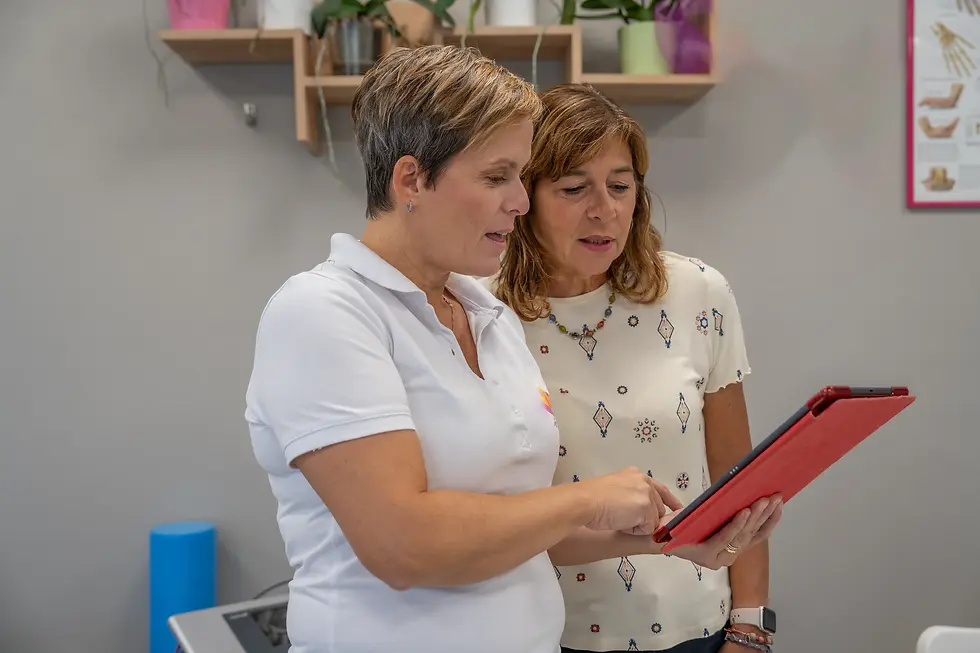 Physiotherapist analyses medical progress with patient on tablet