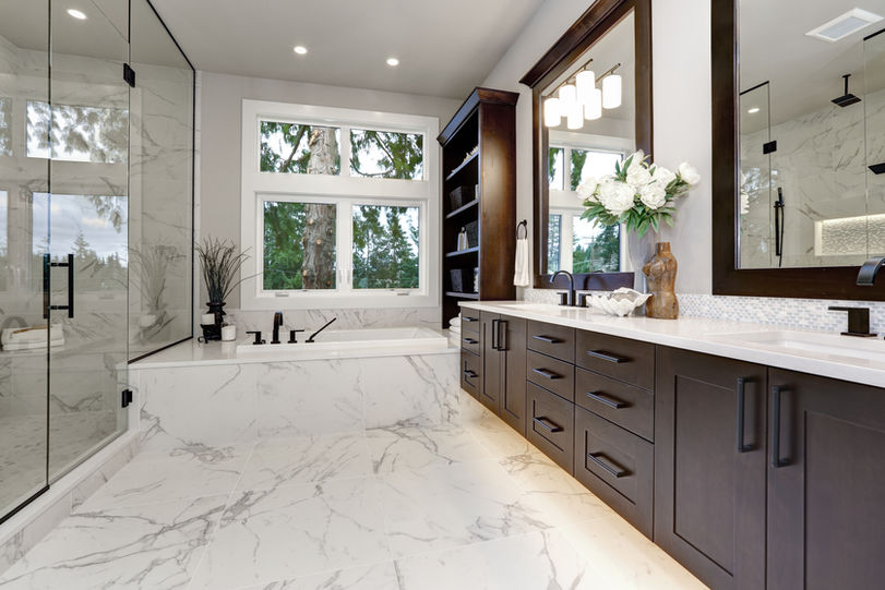 Modern luxury master bathroom with a glass-enclosed rainfall shower, freestanding tub, bespoke double vanity, and warm ambient lighting for a timeless retreat