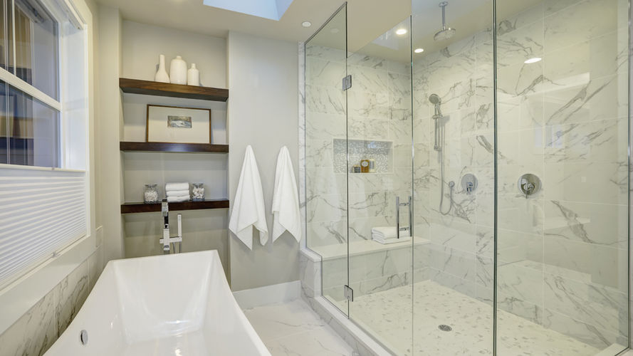 Luxurious spa-style master bathroom with a freestanding tub, warm lighting, and modern fixtures.