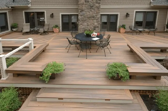 Custom wooden deck with built-in seating, surrounded by greenery, perfect for outdoor relaxation and entertainment.