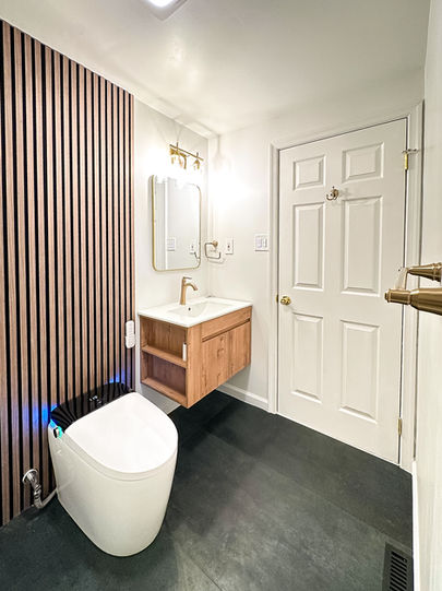 Modern hallway bathroom with floating vanity, LED mirror, and large-format wall tiles in a minimalist design.