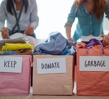 two people making sort, keep, donate, and garbage piles to sort items in the house to make