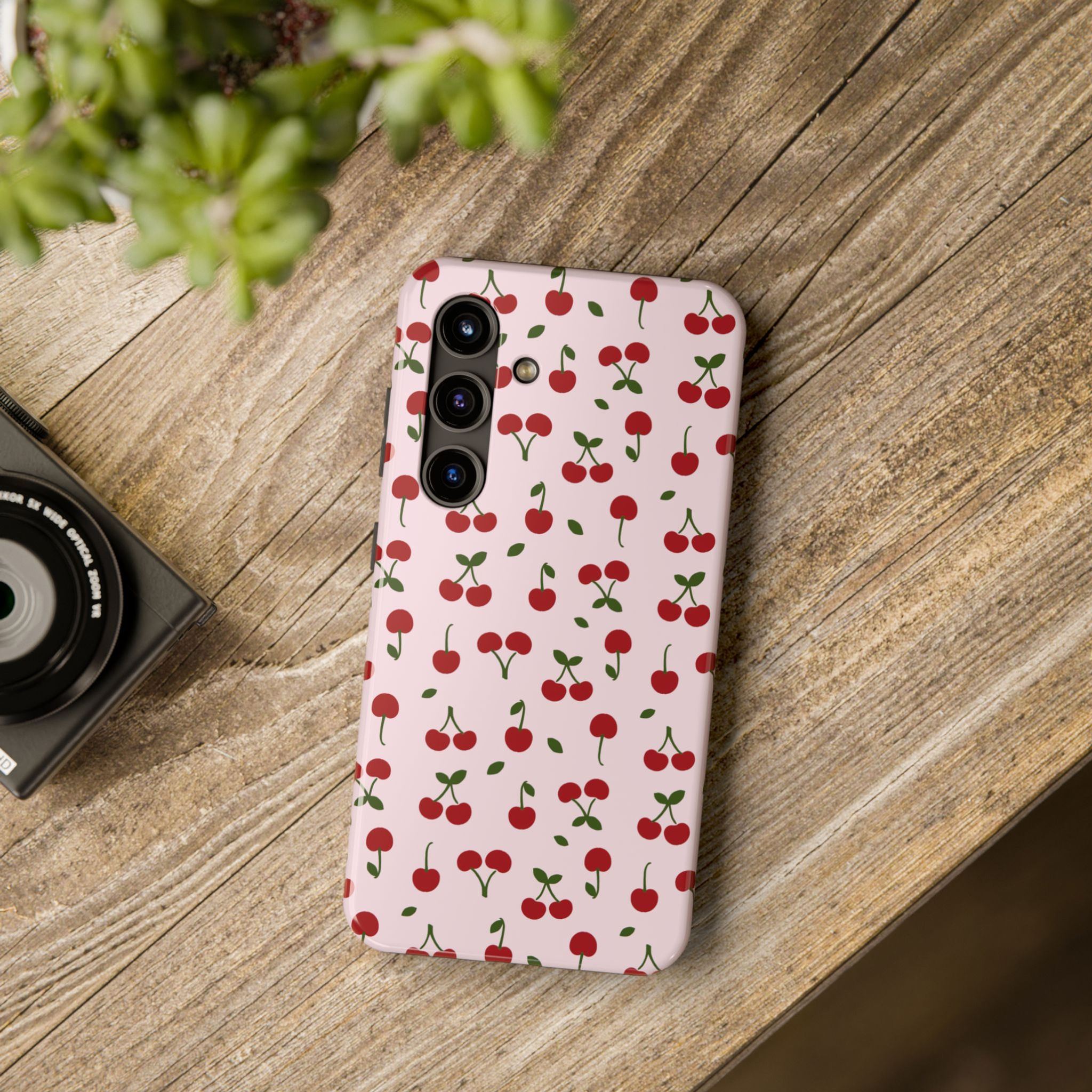Vintage Pink Cherry phone case displayed on a wooden table