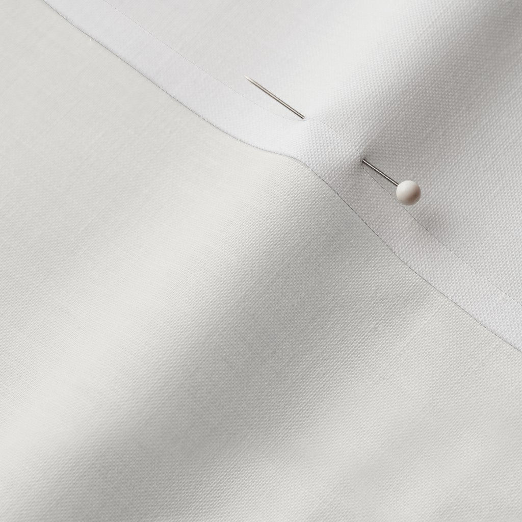 Close-up of white cotton fabric showing the finished edge and texture.