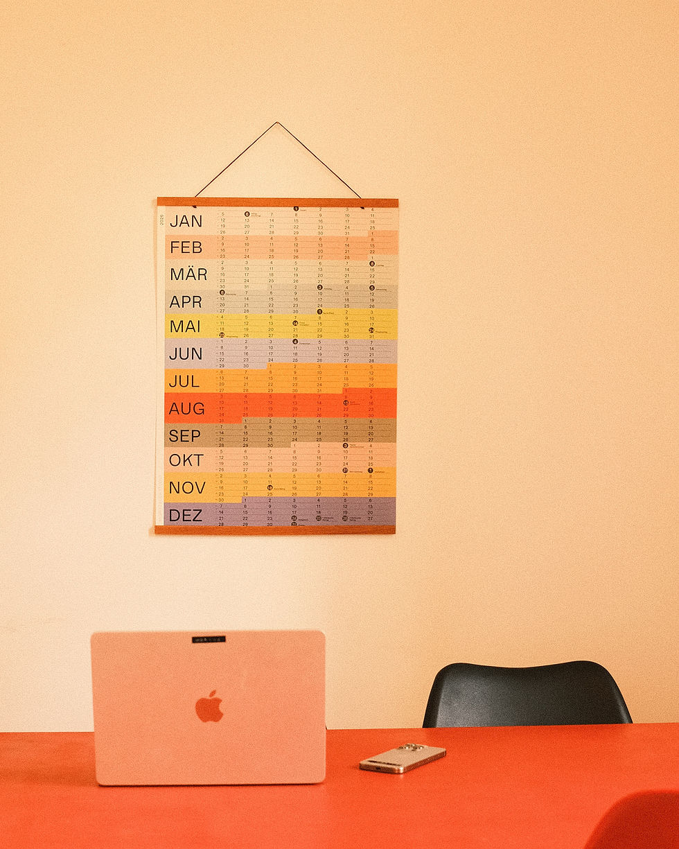 ein bunter Wand Kalender 2026 in einer Altbauwohnung vor einem MacBook Air
