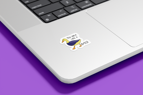 A duck sticker on a silver laptop referencing to the quirky lyric "You Walk Like a Duck Bitch" in the song Groin by RM. The duck is wearing a blue tracksuit jacket and the text You Walk like a B*tch is written along it.