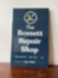 hand painted deep blue sign for bassett repair shop