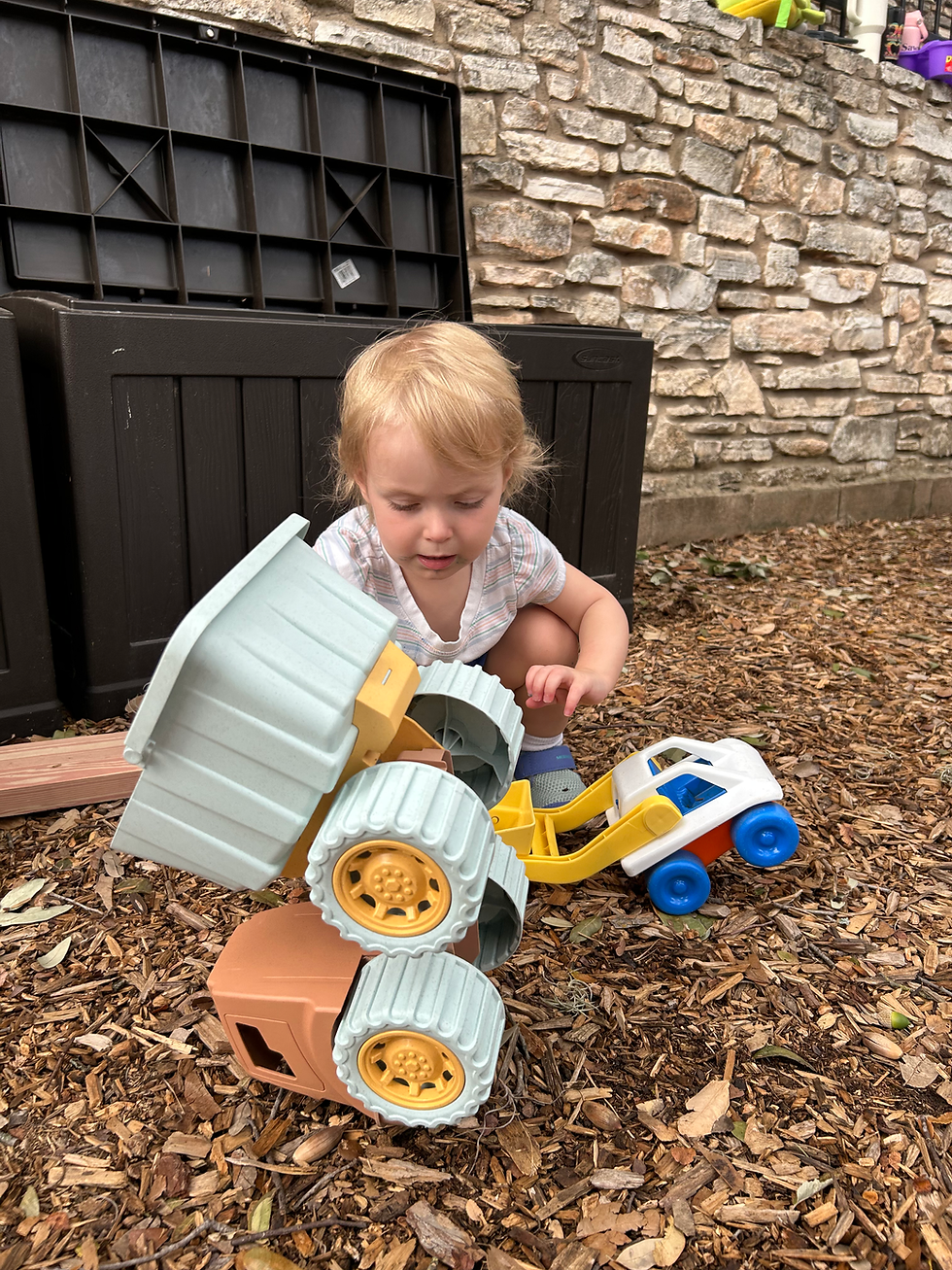 Toddler girl playing with a truck on the Toddler Playground at CHUMS preschool