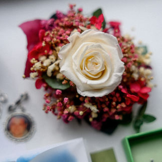 Wedding corsage with a preserved white rose and berry florals.