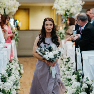 Bridesmaid carrying a preserved white bouquet during the wedding ceremony at the Broadhaven Bay Hote