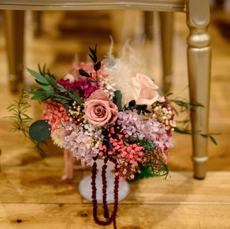 Large preserved floral aisle arrangement in a white urn.