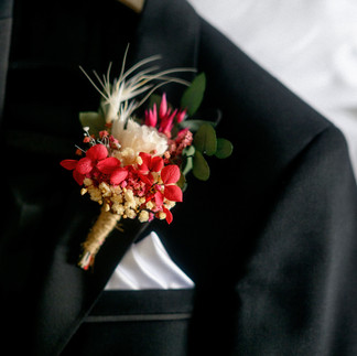 Groom's preserved floral buttonhole featuring white, red and natural dried flowers.