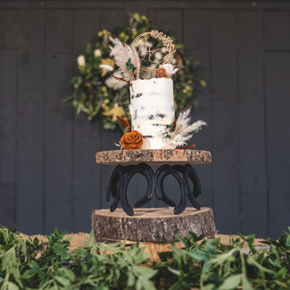 Rustic wedding cake decorated with preserved flowers in terracotta, cream and blush tones