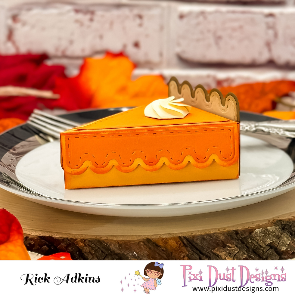 Orange pie box with whipped cream decoration on a white plate, set against a brick wall and autumn leaves. Rick Adkins, Pixi Dust Designs.