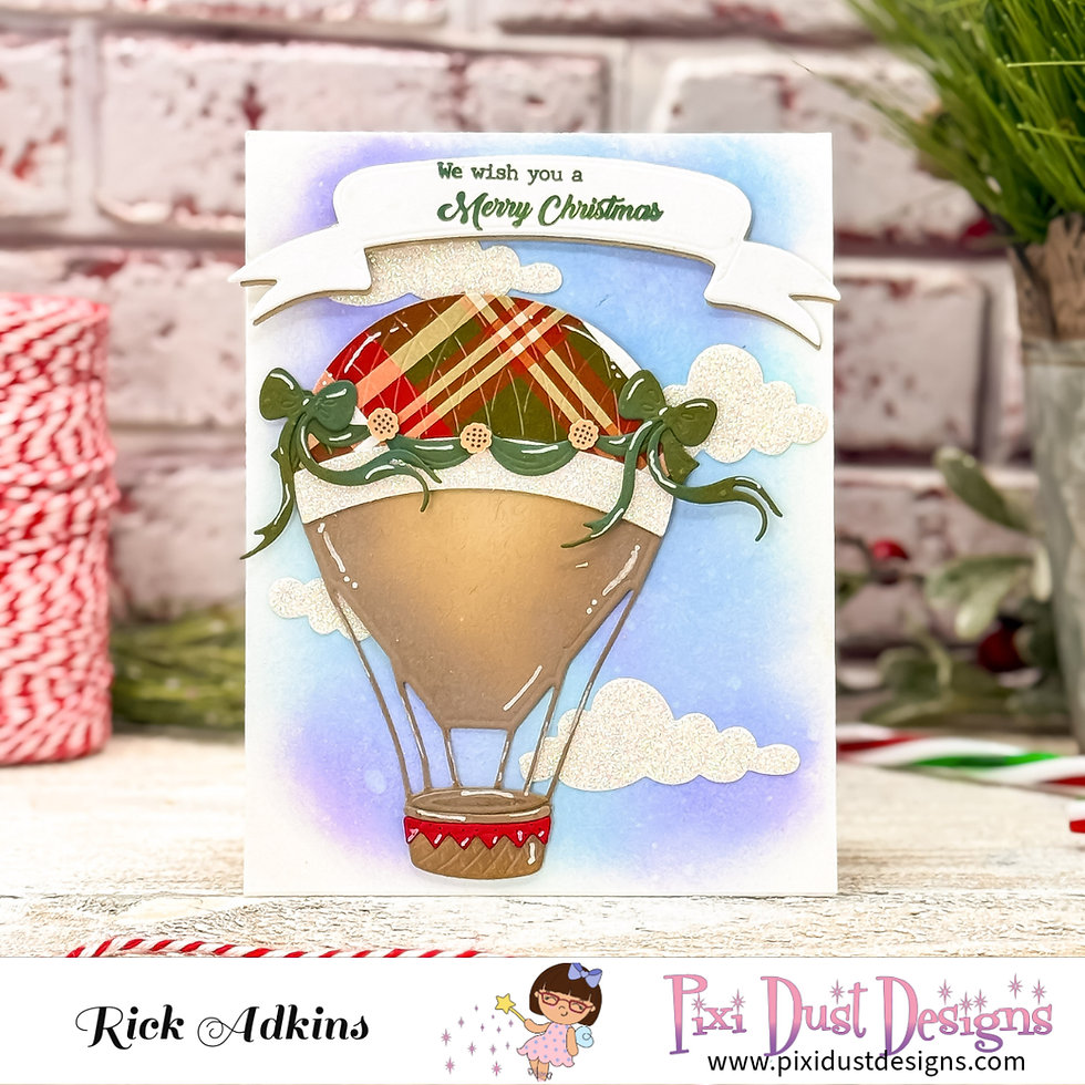 Christmas card with a hot air balloon in plaid design. Text reads "We wish you a Merry Christmas." Brick wall and ribbon spool in background.