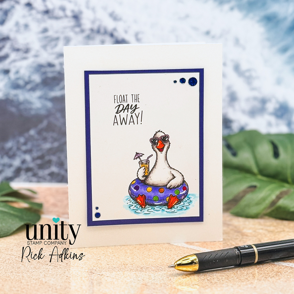 Greeting card with a sunglasses-wearing duck in a purple float, saying Float the Day Away!, on a tabletop with pen and blurred leaves.