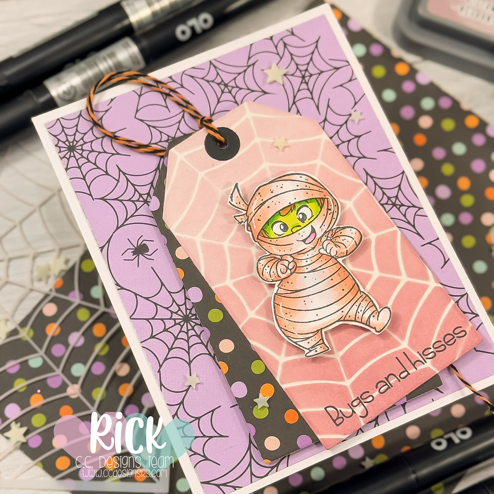 Cute cartoon mummy on a pink tag with spiderwebs, "Bugs and Kisses" text. Purple and polka dot backdrop, Halloween theme.
