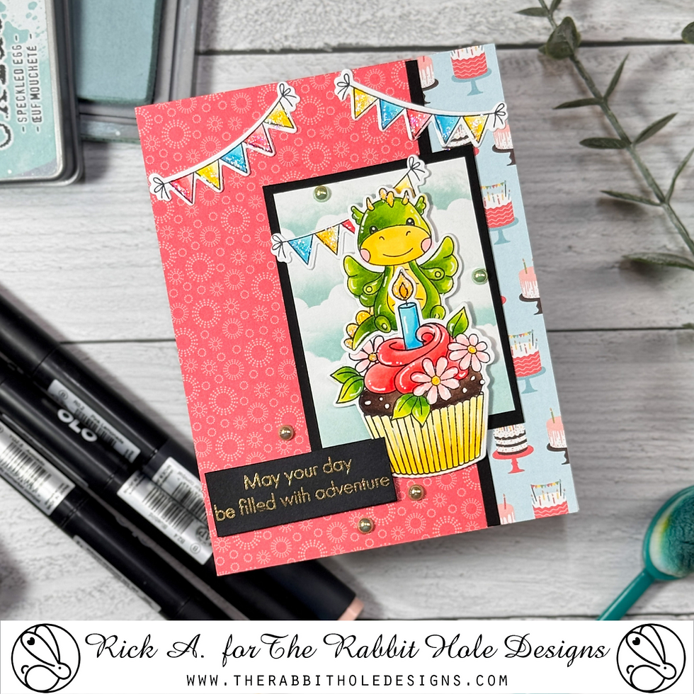 Greeting card with dragon on cupcake, colorful background, and banners. Text reads "May your day be filled with adventure." Festive mood.