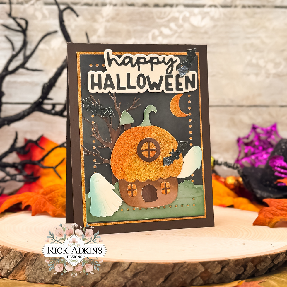 Halloween card with an orange house, ghosts, and bats. "Happy Halloween" text. Surrounded by autumn leaves and branches on wooden surface.
