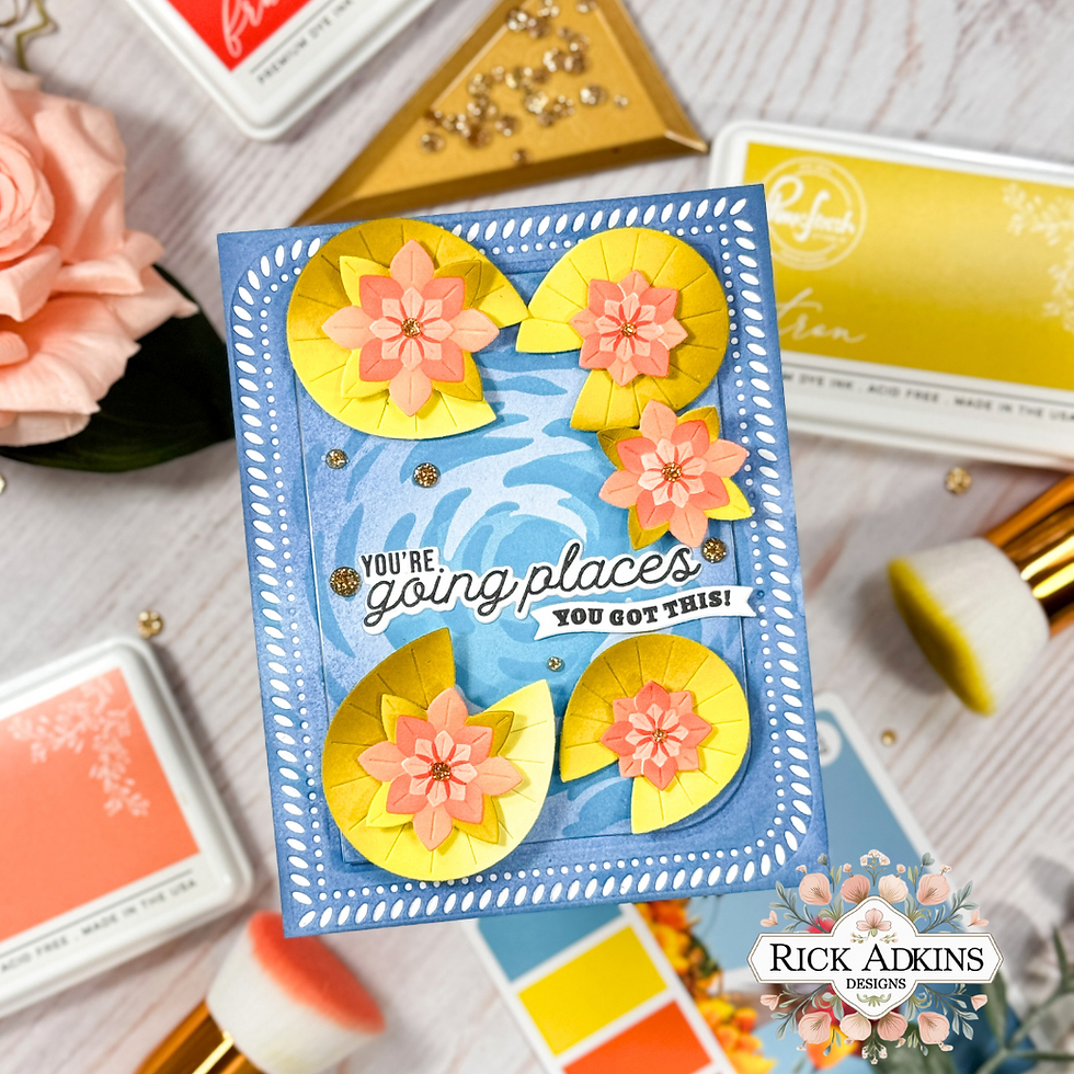 Card with yellow and pink flowers on a blue background, text saying "You're going places, you got this!" Nearby are ink pads and a rose.