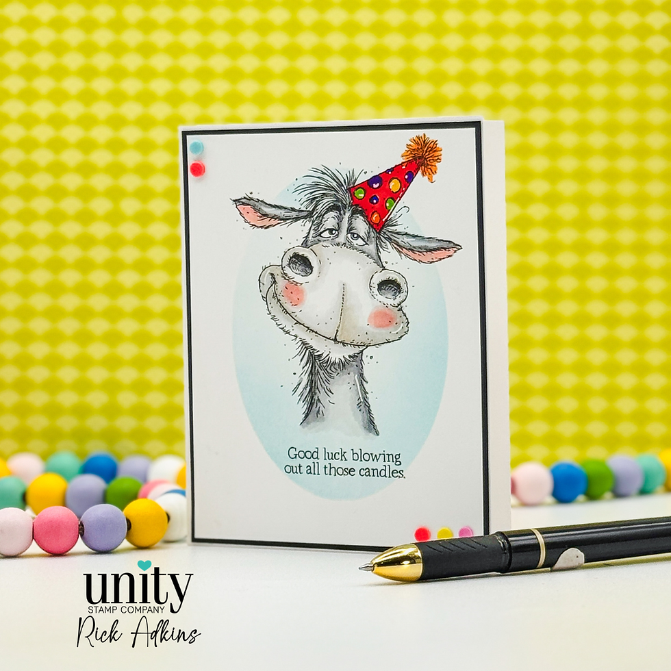Greeting card with a smiling donkey in a party hat, text: "Good luck blowing out all those candles." Colorful beads and a pen nearby.