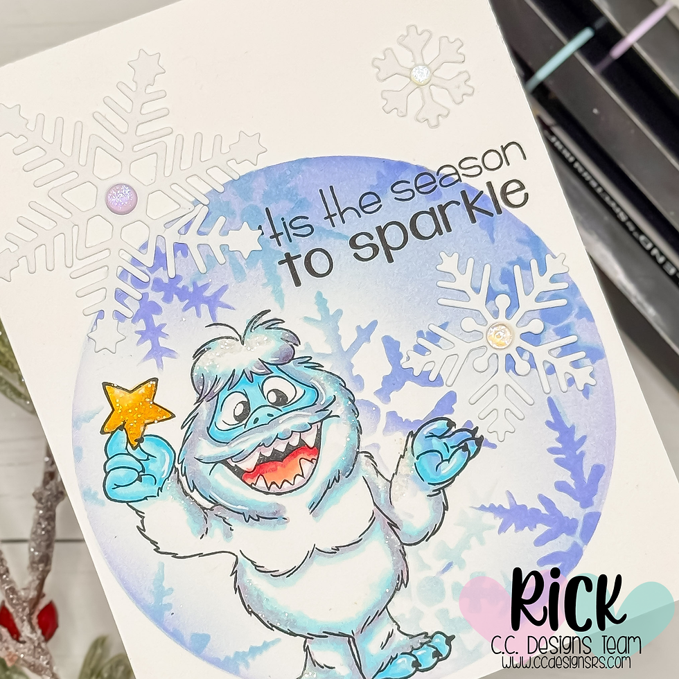 Cartoon yeti with a star, surrounded by snowflakes and blue patterns. Text reads "'tis the season to sparkle." Mood is festive and joyful.