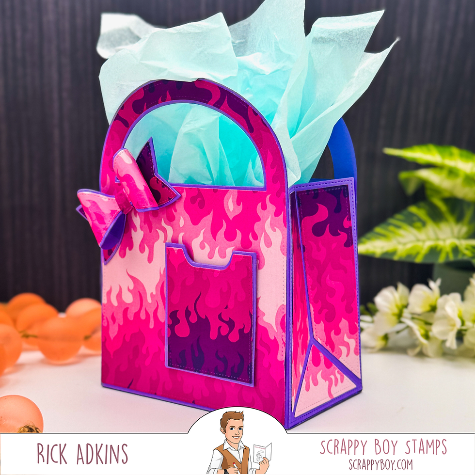 Pink gift bag with flame pattern, blue tissue paper, and pink bow. Background includes orange balls and green plant. Text: Rick Adkins, Scrappy Boy Stamps.