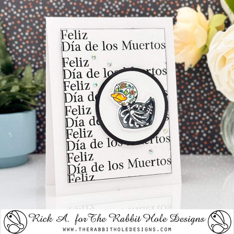 Greeting card with a Day of the Dead duck design and "Feliz Día de los Muertos" text. Background is black with colorful dots.