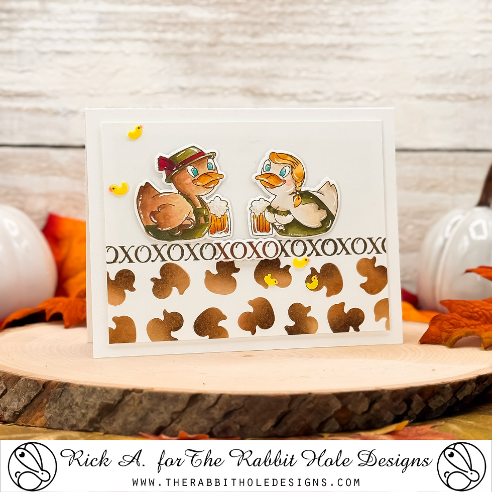 Two cartoon ducks in autumn outfits hold mugs on a greeting card with an "XOXOXO" pattern. Background features autumn leaves.