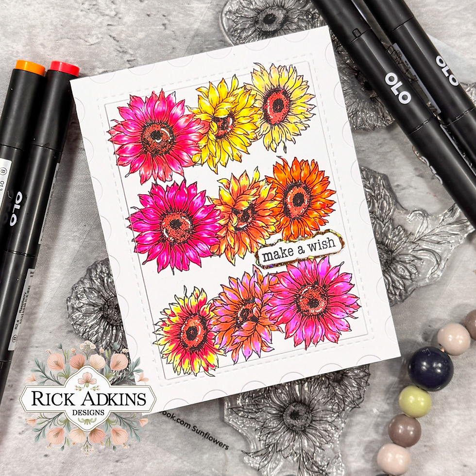 Colorful card with vibrant yellow, orange, and pink sunflowers. Text "make a wish" in center. OLO markers and decorative beads surround.