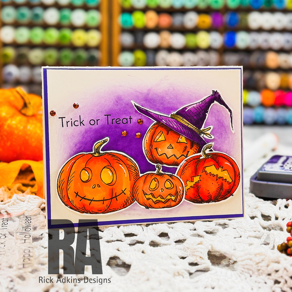 Halloween card with four smiling pumpkins and a witch hat, Trick or Treat text, on a craft table with yarn shelves behind.