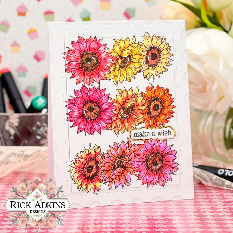 Colorful card with red, yellow, and orange sunflowers, text "make a wish." Background features pastel cupcake patterns and flowers.