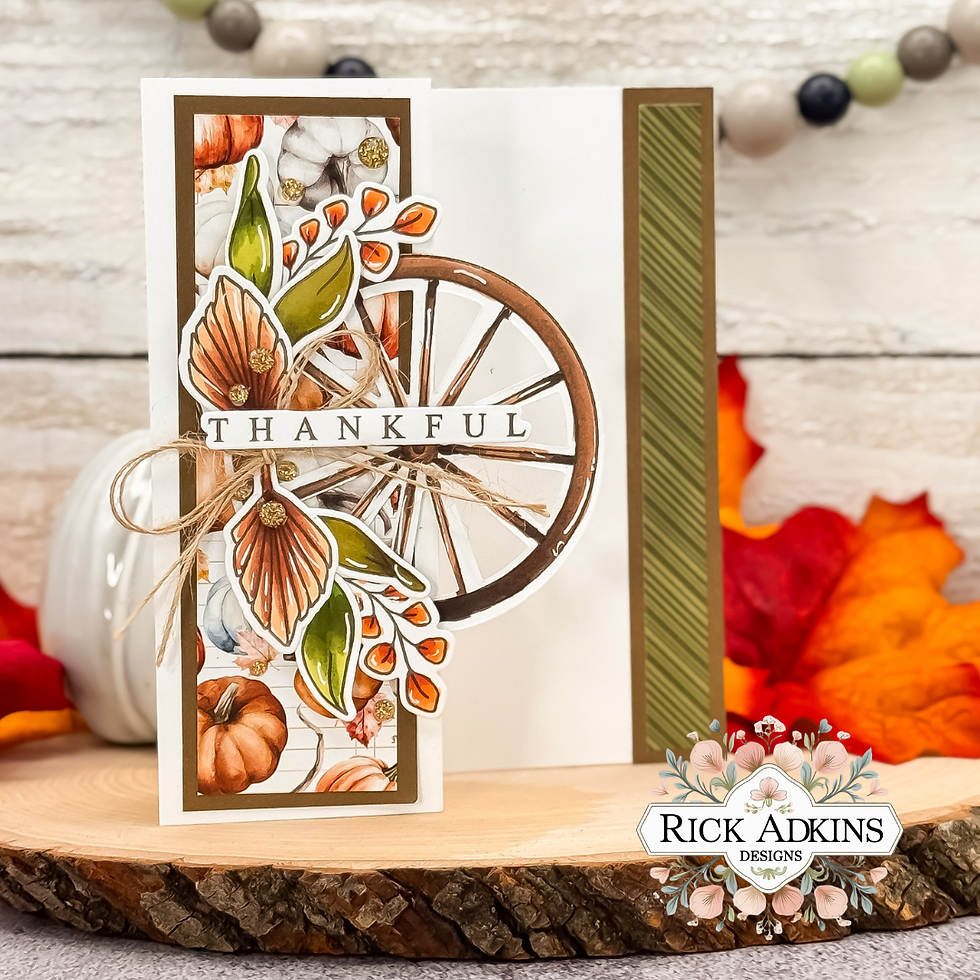 Thanksgiving card with autumn leaves, pumpkins, and a wheel design. "Thankful" text on the card. Warm colors on a wood slice.