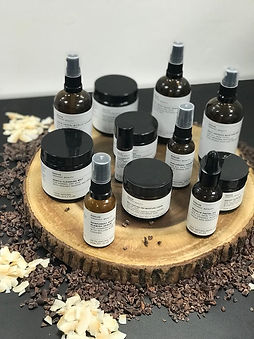 Evolve beauty organic skincare products laid out on a wooden mat on a dark table.
