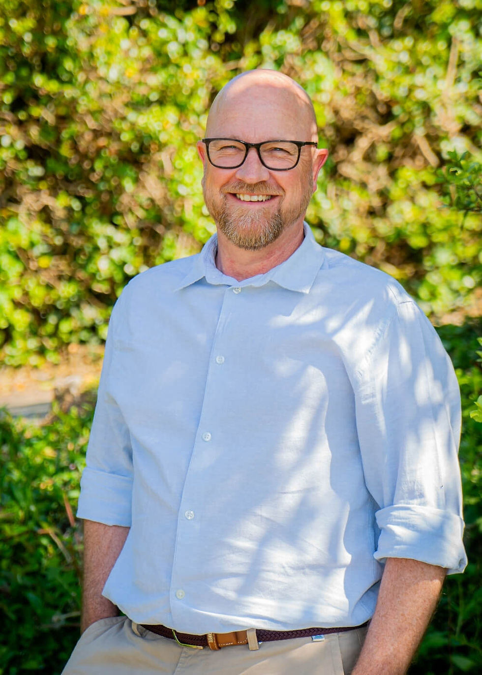 Portrait of man wearing glasses and smiling in natural outdoor setting – Wales.