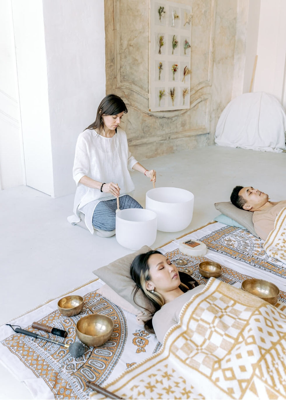 Sound healing session with woman playing crystal singing bowls – soulful photography in Wales.