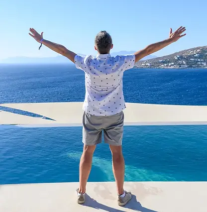 A person standing with arms open, enjoying Boca Raton beach views, symbolizing freedom, self-trust, and emotional healing through IFS therapy.
