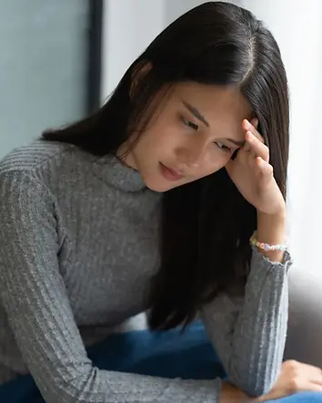 Woman in deep reflection during a guided past life regression therapy session, exploring emotions and subconscious memories in a calm, peaceful setting.