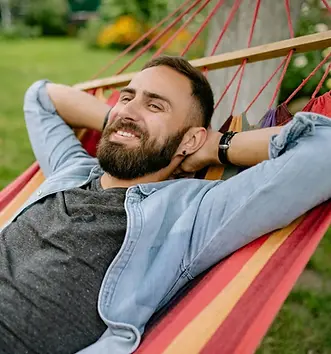 a man on a swing smiling after taking therapy as business owner.