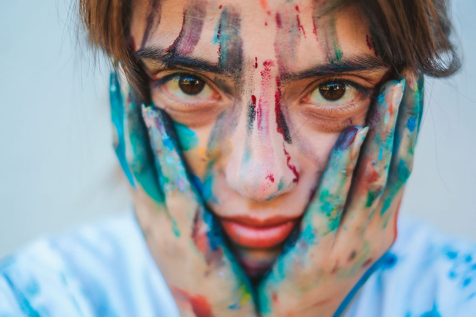 A person with paint on their hands and face