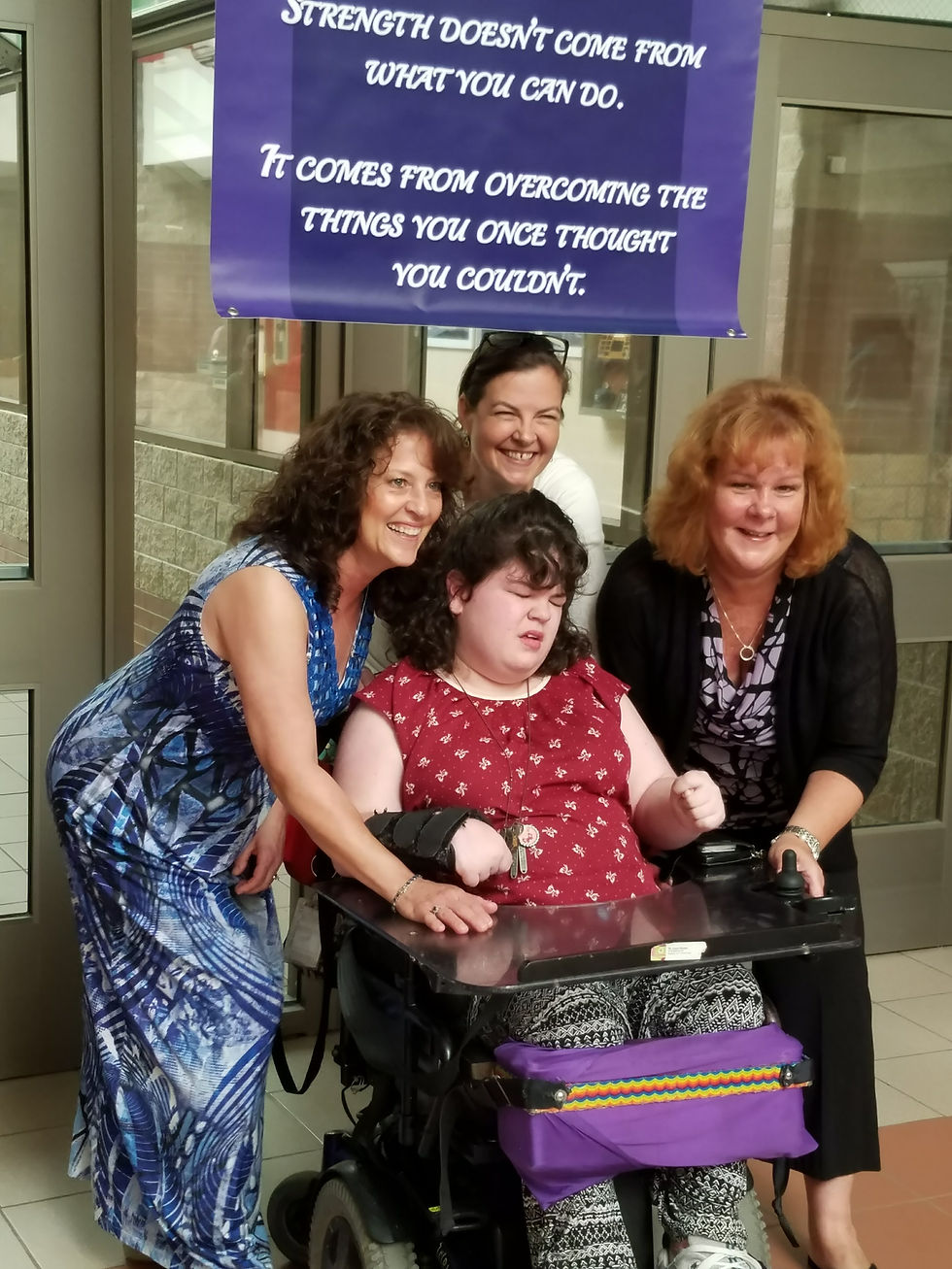 Photo of me surrounded by my tow assistants and Special Education teacher Ms. Ryan. They are surrounding me, beaming with pride above their heads hangs a banner that says Strength doesn't come from what you can do. It comes from overcoming the things you once thought you couldn't.