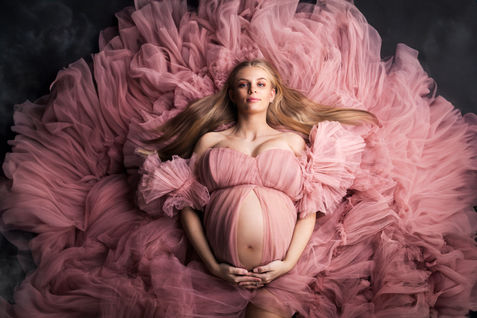 Studio photos of a young mum to be in a beautiful pink floaty dress