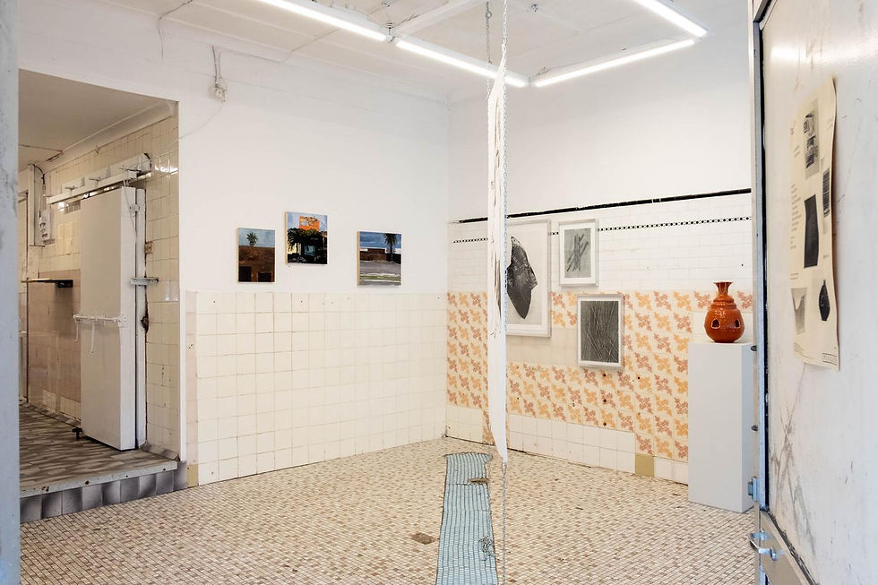 Art gallery with tiled walls, framed artworks, and an orange vase. Neutral colors, geometric patterns, and bright lighting create a minimalist vibe.