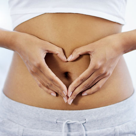 woman making a heart sign around her stomach to signify gut health