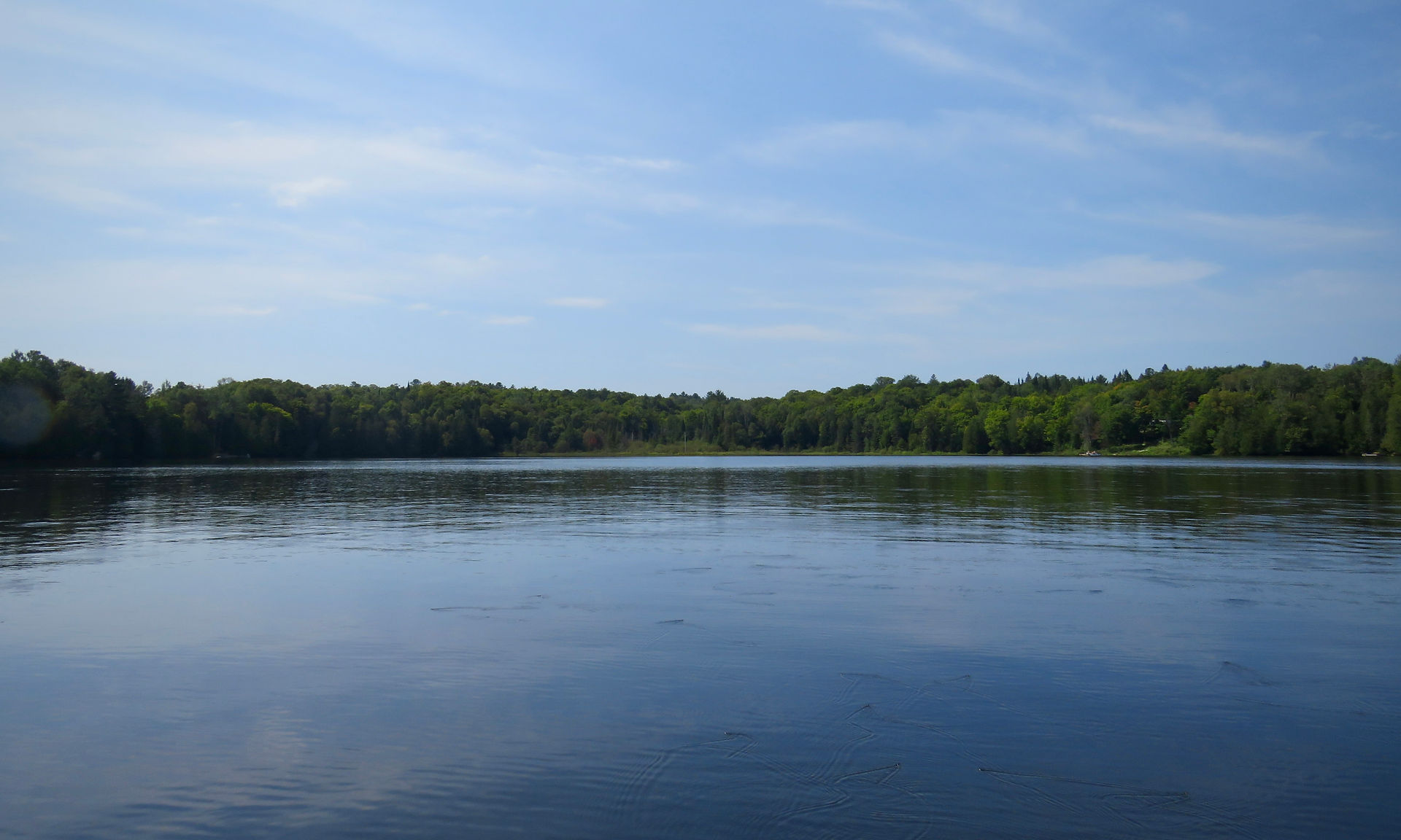 Lake shore landscape reflecting on calm water
