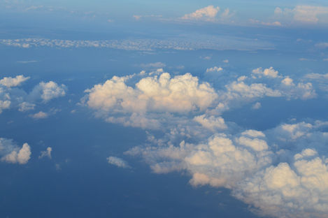 Clouds from above with hazy light, taken from airplane window, DSLR photo.